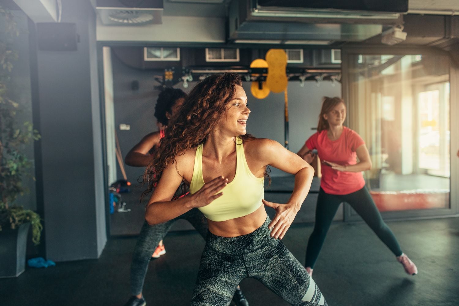 Women doing group fitness class in gym studio