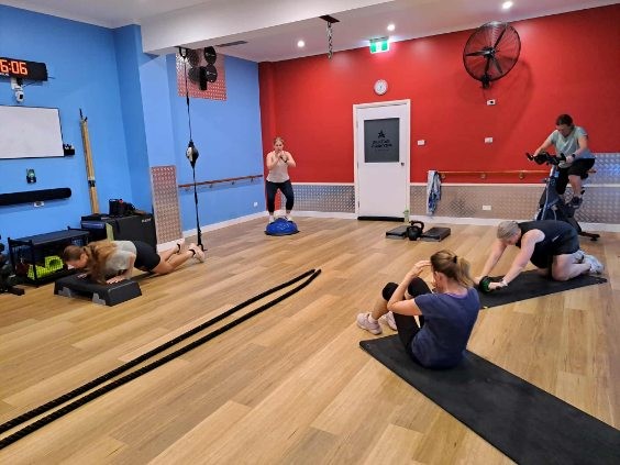 People exercising in colourful indoor fitness studio