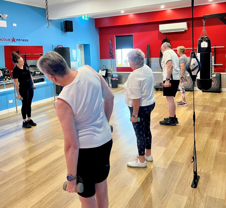 Older adults doing low-impact mobility exercises with dumbbells at Active Fitness Medowie