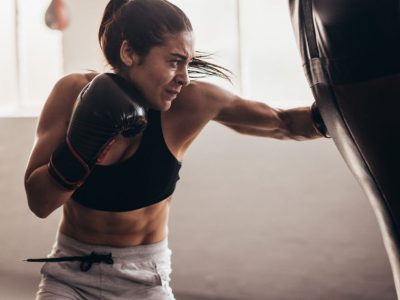 Female Boxer Striking a Heavy Bag for Cardio and Power